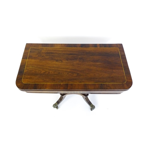 1560 - A Regency rosewood card table with inlaid brass stringing, the revolving top opening to show a baize... 