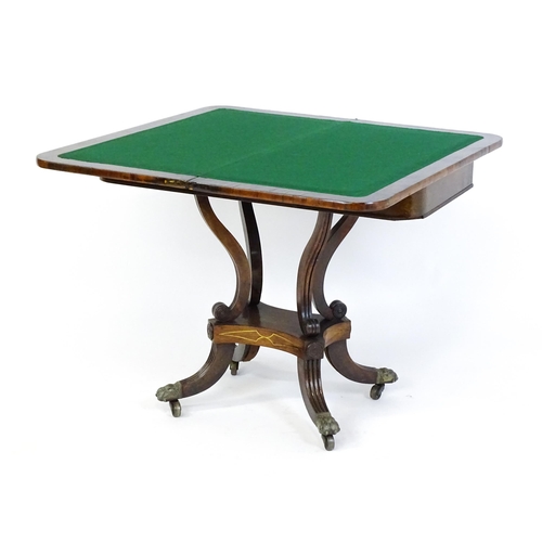 1560 - A Regency rosewood card table with inlaid brass stringing, the revolving top opening to show a baize... 