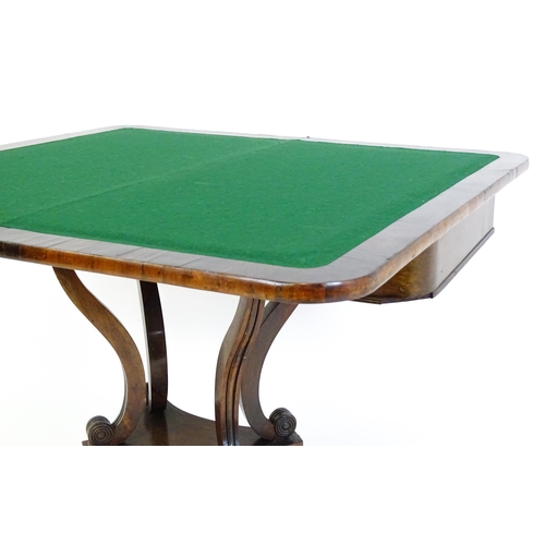 1560 - A Regency rosewood card table with inlaid brass stringing, the revolving top opening to show a baize... 