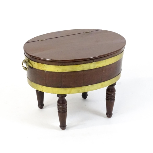 1561 - An early 19thC mahogany cellarette with a hinged lid above brass coopering and flanked by carrying h... 