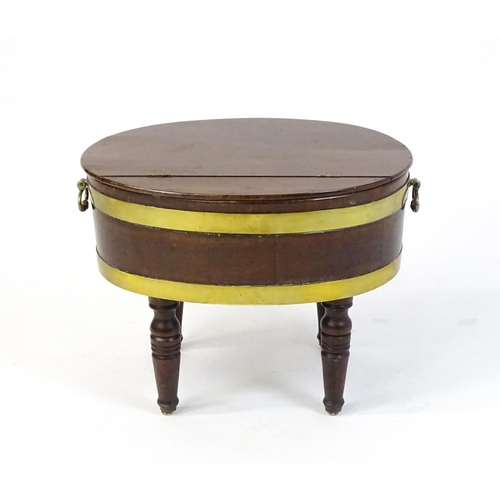 1561 - An early 19thC mahogany cellarette with a hinged lid above brass coopering and flanked by carrying h... 