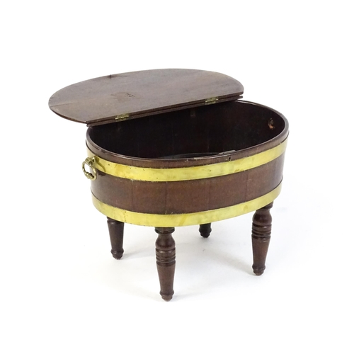 1561 - An early 19thC mahogany cellarette with a hinged lid above brass coopering and flanked by carrying h... 