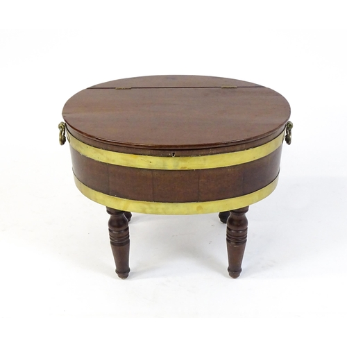 1561 - An early 19thC mahogany cellarette with a hinged lid above brass coopering and flanked by carrying h... 