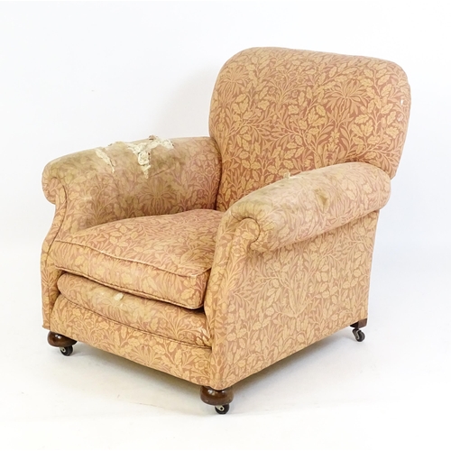 1584 - A late 19thC / early 20thC armchair with scrolled arms and raised on bun feet and castors. 36