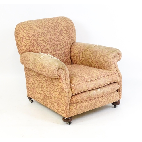 1584 - A late 19thC / early 20thC armchair with scrolled arms and raised on bun feet and castors. 36