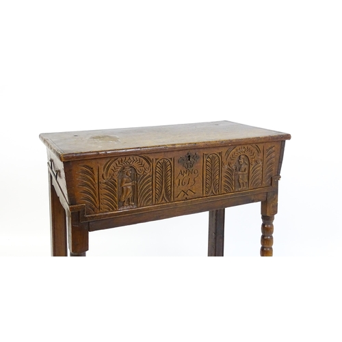 1597 - An 18thC oak box on stand with a carved front panel above a hinged lid, the box raised on four bobbi... 