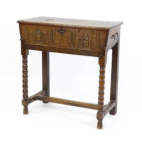 1597 - An 18thC oak box on stand with a carved front panel above a hinged lid, the box raised on four bobbi... 