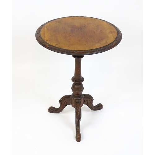 1605 - A late 19thC tripod table with a carved rim above a turned pedestal and three carved cabriole legs. ... 