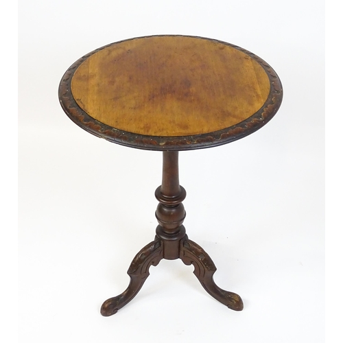 1605 - A late 19thC tripod table with a carved rim above a turned pedestal and three carved cabriole legs. ... 