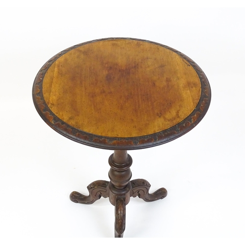 1605 - A late 19thC tripod table with a carved rim above a turned pedestal and three carved cabriole legs. ... 