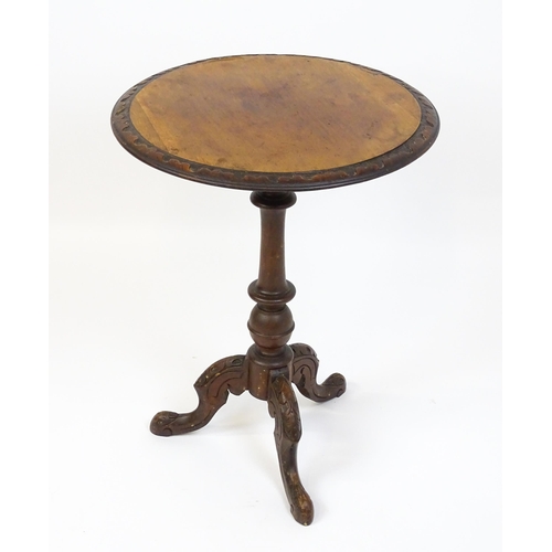 1605 - A late 19thC tripod table with a carved rim above a turned pedestal and three carved cabriole legs. ... 