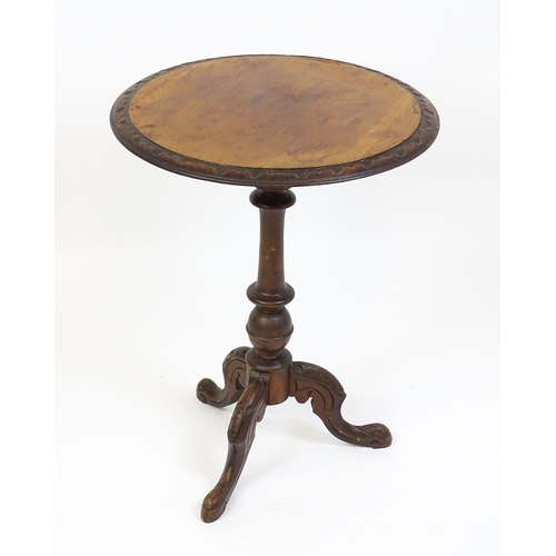 1605 - A late 19thC tripod table with a carved rim above a turned pedestal and three carved cabriole legs. ... 