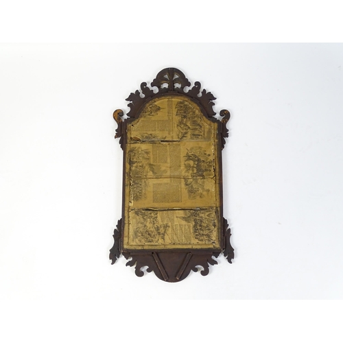 1610 - An early 20thC walnut wall mirror surmounted by a gilt Fleur de Lys, carved scrolled decoration and ... 