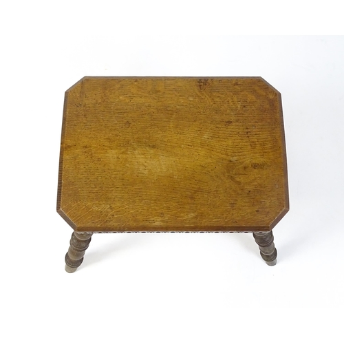 1615 - An early 20thC oak stool with an octagonal canted top and nulled carving and the top raised on four ... 