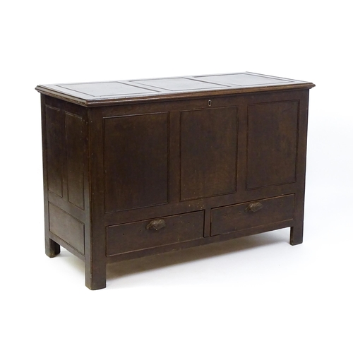 1622 - An early 18thC oak mule chest with a hinged, panelled lid above a panelled front and two short drawe... 