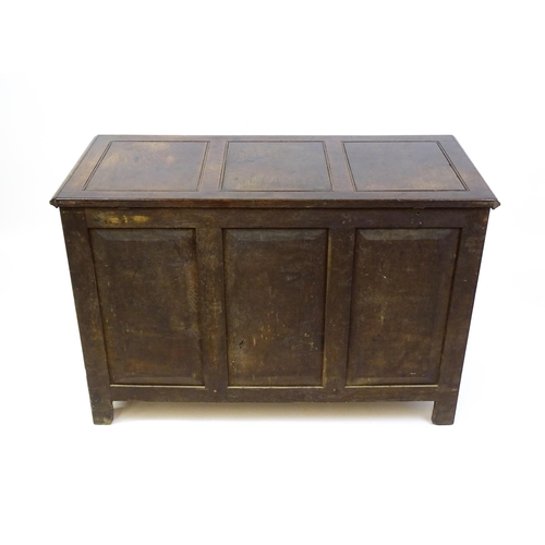 1622 - An early 18thC oak mule chest with a hinged, panelled lid above a panelled front and two short drawe... 