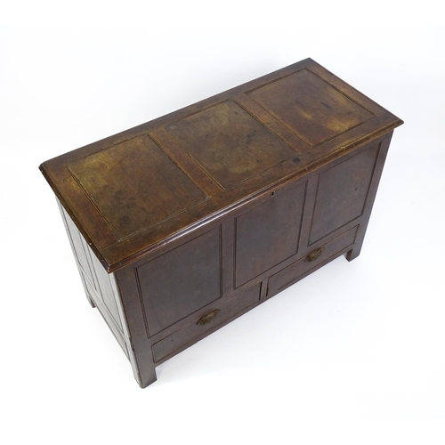 1622 - An early 18thC oak mule chest with a hinged, panelled lid above a panelled front and two short drawe... 