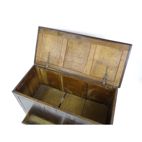 1622 - An early 18thC oak mule chest with a hinged, panelled lid above a panelled front and two short drawe... 