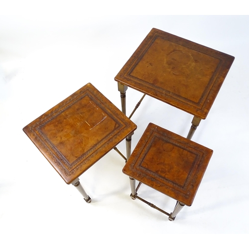 1623 - A mid 20thC nest of three tables with inset leather tops above turned supports united by tapering st... 