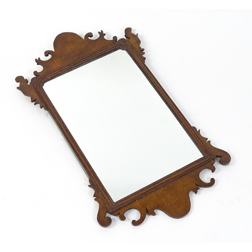 1636 - A late 19thC / early 20thC mahogany wall mirror with scrolled detailing and a moulded surround. 16