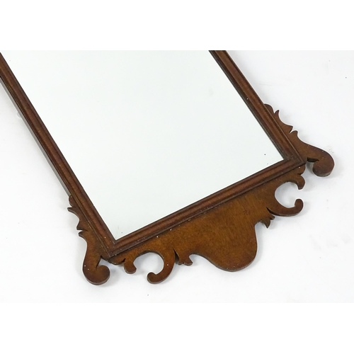 1636 - A late 19thC / early 20thC mahogany wall mirror with scrolled detailing and a moulded surround. 16