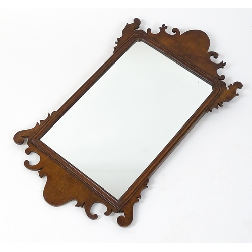 1636 - A late 19thC / early 20thC mahogany wall mirror with scrolled detailing and a moulded surround. 16