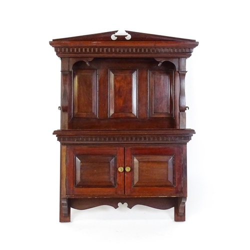 1637 - An early 20thC mahogany wall hanging cabinet with a neo - classical style pediment above a dentil mo... 