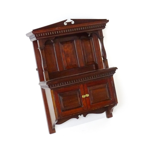 1637 - An early 20thC mahogany wall hanging cabinet with a neo - classical style pediment above a dentil mo... 