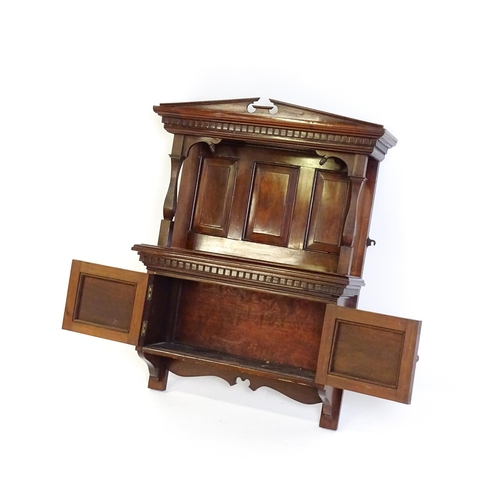 1637 - An early 20thC mahogany wall hanging cabinet with a neo - classical style pediment above a dentil mo... 