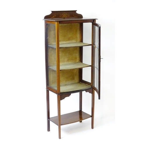 1641 - An Edwardian mahogany display cabinet with a marquetry inlaid upstand with a single glazed door, hav... 