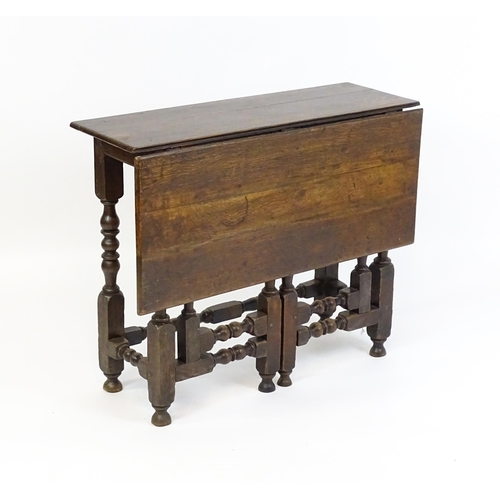 1644 - An 18thC oak gateleg table with a single leaf supported by a double gateleg mechanism formed of bloc... 