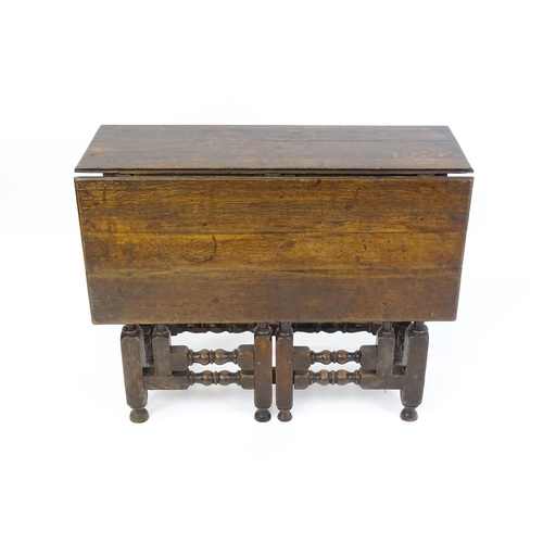 1644 - An 18thC oak gateleg table with a single leaf supported by a double gateleg mechanism formed of bloc... 