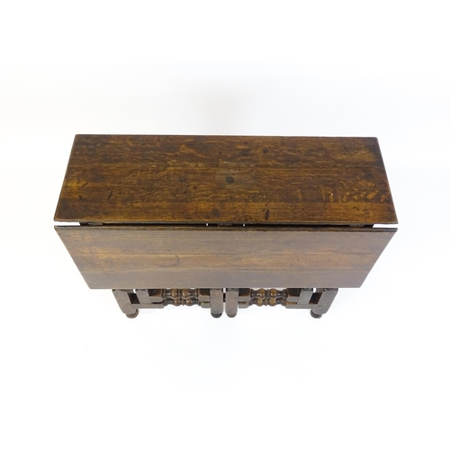 1644 - An 18thC oak gateleg table with a single leaf supported by a double gateleg mechanism formed of bloc... 