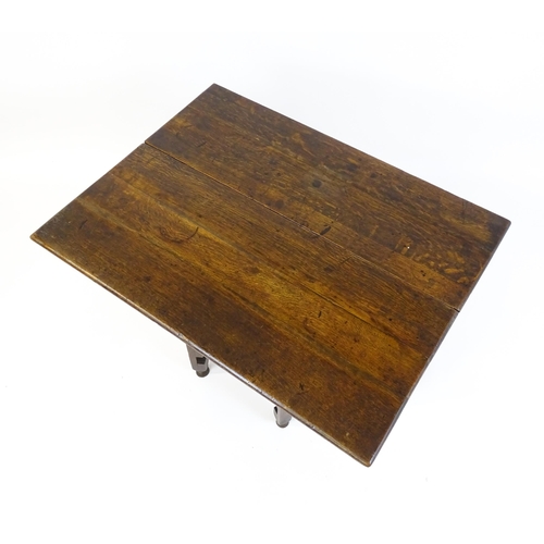 1644 - An 18thC oak gateleg table with a single leaf supported by a double gateleg mechanism formed of bloc... 