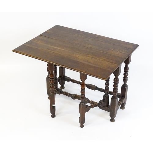 1644 - An 18thC oak gateleg table with a single leaf supported by a double gateleg mechanism formed of bloc... 