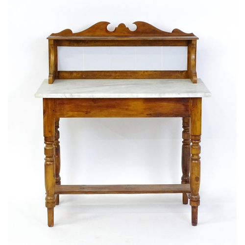 1647 - An early 20thC washstand with a tiled splashback above a marble top raised on four turned tapering l... 