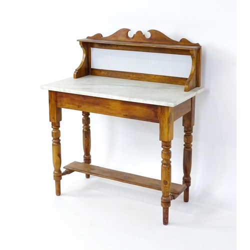 1647 - An early 20thC washstand with a tiled splashback above a marble top raised on four turned tapering l... 