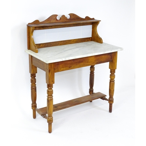 1647 - An early 20thC washstand with a tiled splashback above a marble top raised on four turned tapering l... 