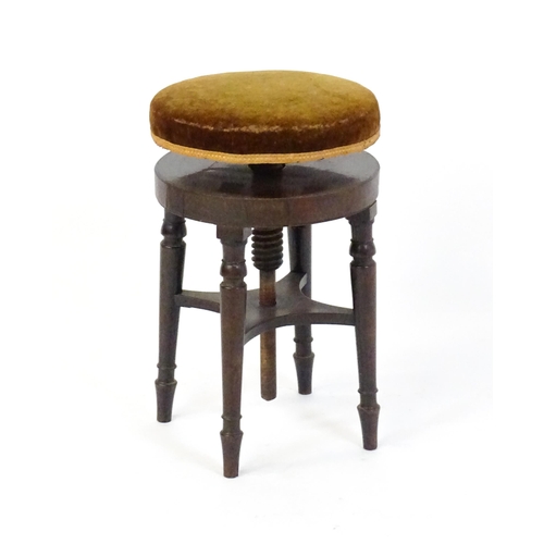 1657 - A 19thC mahogany piano stool with an adjustable upholstered top raised on four turned legs united by... 