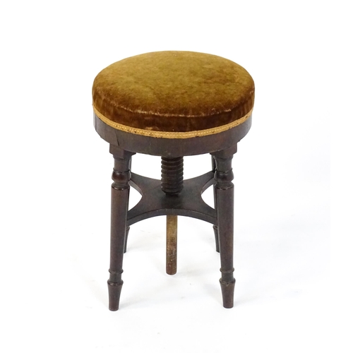 1657 - A 19thC mahogany piano stool with an adjustable upholstered top raised on four turned legs united by... 