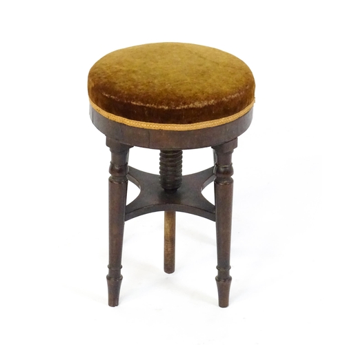 1657 - A 19thC mahogany piano stool with an adjustable upholstered top raised on four turned legs united by... 