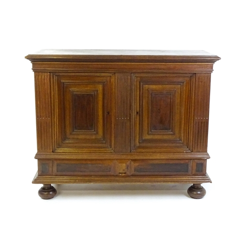 1660 - A late 19thC / early 20thC walnut cupboard with a moulded top above two panelled doors and a fluted ... 