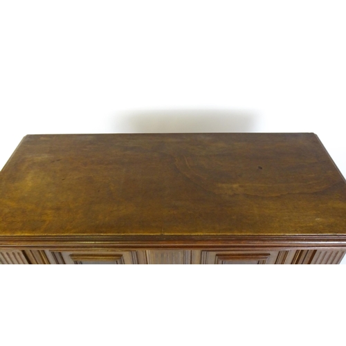 1660 - A late 19thC / early 20thC walnut cupboard with a moulded top above two panelled doors and a fluted ... 