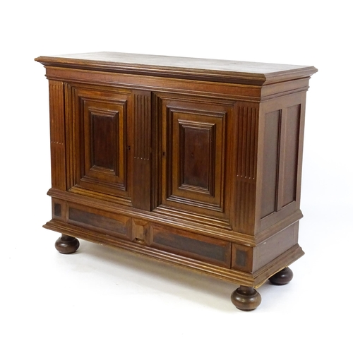 1660 - A late 19thC / early 20thC walnut cupboard with a moulded top above two panelled doors and a fluted ... 