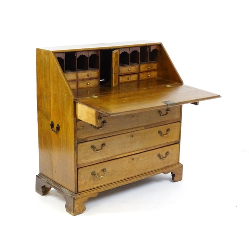 1662 - A Georgian oak bureau with a fall front opening to show crossbanded drawers, a marquetry inlaid door... 