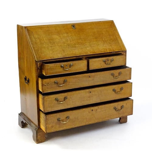 1662 - A Georgian oak bureau with a fall front opening to show crossbanded drawers, a marquetry inlaid door... 