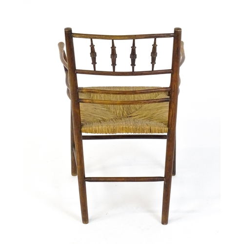 1667 - A late 19thC Arts & Crafts Sussex chair by William Morris. The chair with a spindle turned and doubl... 