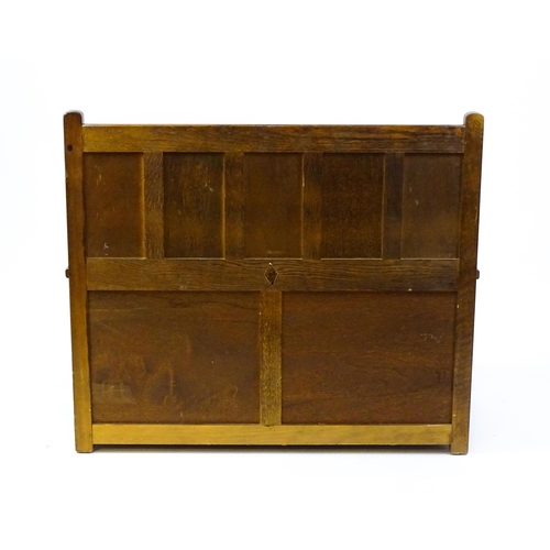 1673 - An early 20thC Old Charm monks bench with a chamfered frame, carved oak panels and a hinged seat. 39... 