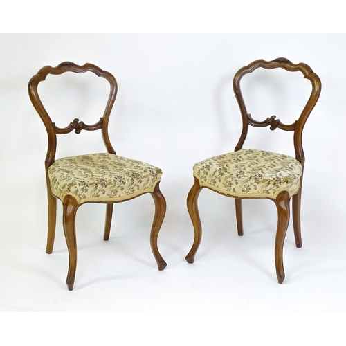 1676 - A pair of late 19thC walnut balloon back bedroom chairs with carved top and mid rails above cabriole... 