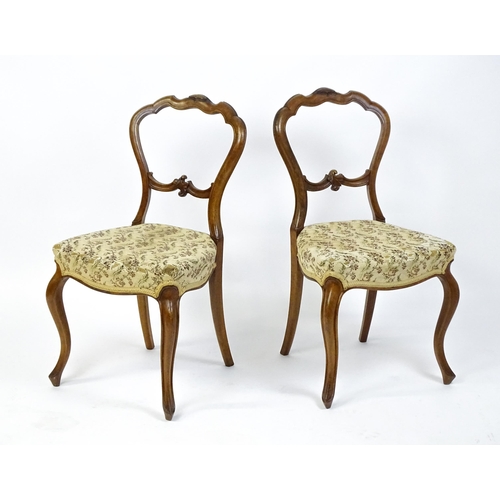 1676 - A pair of late 19thC walnut balloon back bedroom chairs with carved top and mid rails above cabriole... 